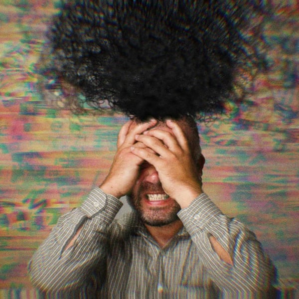 A man with his hands on his head in frustration. An abstract black cloud rises from his brain, symbolizing chaos