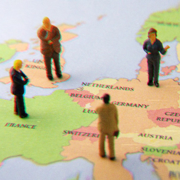Figurines of people standing on a partial map of Europe