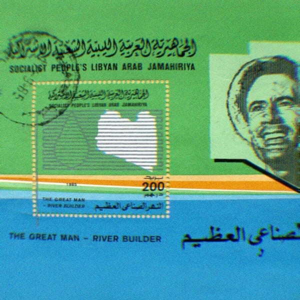 Stamp commemorating Gaddafi as River Builder. His photo accompanies text that reads ‘Socialist People’s Libyan Arab Jamahiriya. The Great Man - River Builder.’