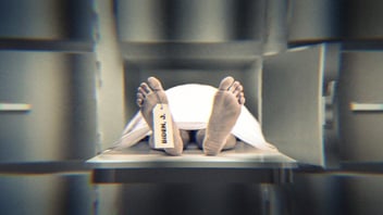 A body in a morgue locker. Feet are sticking out and a toe tag reads, 'Biden, J.'