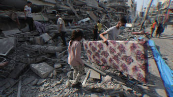 Palestinians inspect the ruins of Aklouk Tower destroyed in Israeli airstrikes in Gaza City on October 2023.