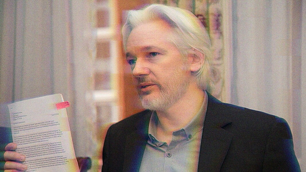A photo of Julian Assange holding a document.